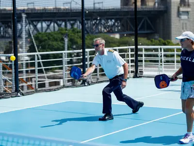Kapitän Pieter Bant beim Pickleball-Spiel an Bord der Noordam auf dem Sportdeck im Hafen von Sydney.