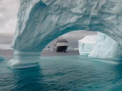 Blick durch einen riesigen Eisbogen auf die Oosterdam, die durch die eisigen Gewässer der Antarktis fährt.
