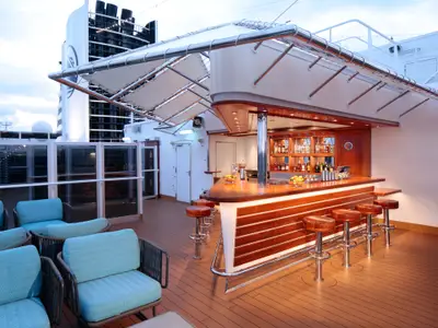Die stilvolle Außenbar an Bord der Rotterdam bietet Holz-Barhocker, gemütliche Sessel und eine reich bestückte Theke.