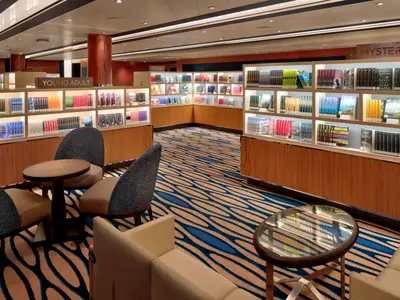 Die modern gestaltete Bibliothek an Bord der Rotterdam mit gefüllten Bücherregalen und komfortablen Sitzgruppen.