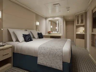 Rendering einer stilvollen Innenkabine an Bord der Rotterdam mit Doppelbett, hellem Holz und warmem Licht.