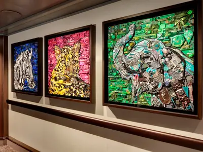 Drei farbenfrohe Kunstwerke an einer Wand an Bord der Rotterdam, die Tiere aus recycelten Objekten zeigen.
