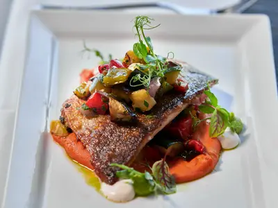 Ein im Restaurant Canaletto an Bord der Rotterdam serviertes Seebarsch-Gericht mit buntem Gemüse und Püree.