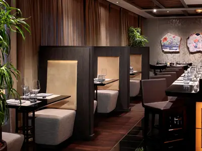 Gemütliche und elegante Sitzecken mit gedeckten Tischen im Restaurant an Bord der Rotterdam.