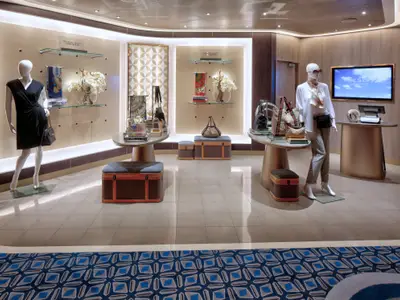 Blick in die elegante Boutique an Bord der Rotterdam mit Schaufensterpuppen, exklusiven Handtaschen und stilvoller Einrichtung.