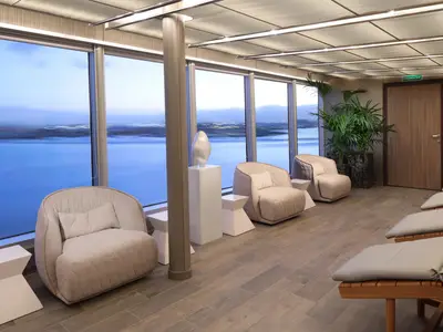 Blick in den eleganten Wellnessbereich an Bord der Rotterdam mit gemütlichen Sesseln, Liegen und Panoramablick auf das Meer.