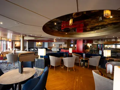 Blick in die elegante Ocean Bar an Bord der Volendam mit gemütlichen Sitzgruppen und Spiegeldecke.