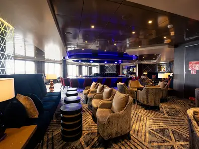 Stilvolle Sessel und gemütliche Sitzecken in der Piano Bar an Bord der Volendam.