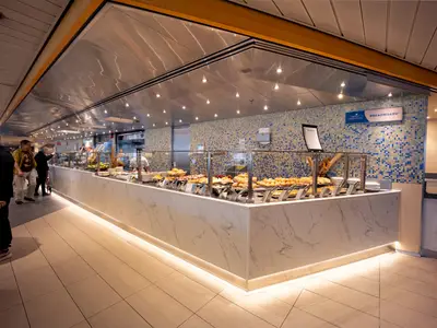 Gäste bedienen sich am 'Breadboard' Buffet an Bord der Volendam, das mit einer edlen Marmortheke gestaltet ist.
