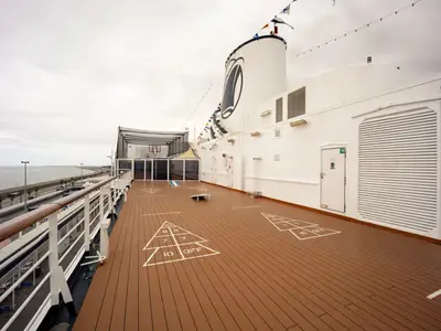 Ein weitläufiges Holzdeck an Bord der Volendam mit eingezeichneten Spielfeldern für Shuffleboard.