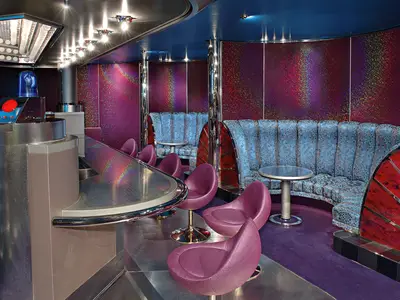 Der Northern Lights Night Club an Bord der Westerdam mit violetten Sesseln, glitzernden Wänden und einer Bar.