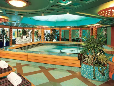 Der einladende Hydrotherapie-Pool an Bord der Westerdam, umgeben von Liegestühlen, Mosaikfliesen und tropischen Pflanzen.