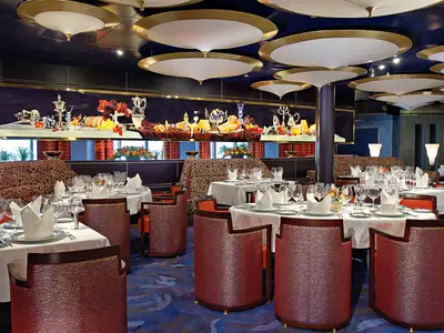 Festlich eingedeckte Tische und gemusterte Sessel im Restaurant Pinnacle Grill an Bord der Westerdam.