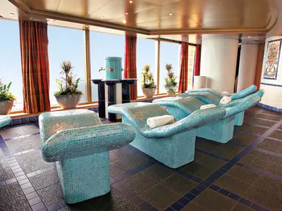 Die hellblauen, beheizten Mosaik-Liegen im Spa-Bereich mit großen Fenstern an Bord der Westerdam.