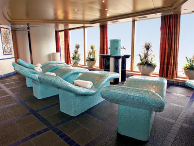 Blick in den Spa-Bereich an Bord der Westerdam mit türkis gefliesten Thermalliegen und Meerblick.