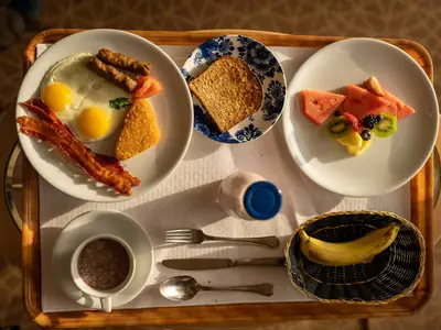 Blick von oben auf ein reichhaltiges Frühstückstablett mit Eiern, Speck, Toast und Obst an Bord der Westerdam.