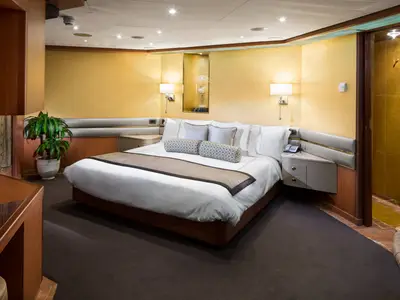 Blick in eine geräumige Suite an Bord der Westerdam mit großem Doppelbett und eleganter Einrichtung.