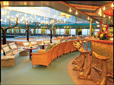 Die stilvolle Lido Bar an Bord der Zuiderdam mit goldenen Hockern in Fischform, gemütlichen Korbsesseln und warmen Lichtinstallationen.