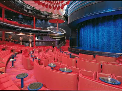 Blick in das große Theater Vista Lounge an Bord der Zuiderdam mit roter Bestuhlung und blauer Bühne.
