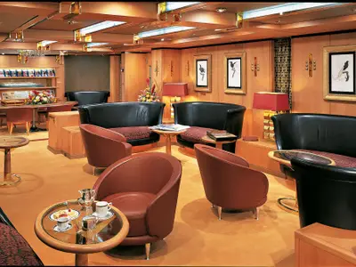 Die klassisch eingerichtete Explorer's Lounge an Bord der Zuiderdam mit edler Holzvertäfelung und gemütlichen Sesseln.