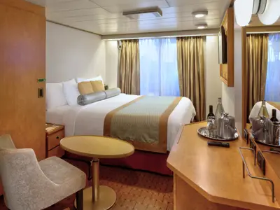 Eine gemütlich eingerichtete barrierefreie Kabine an Bord der Zuiderdam mit großem Doppelbett, Schreibtisch und Sitzecke.