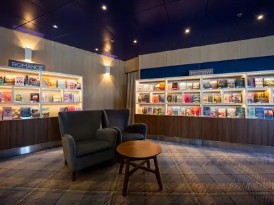 Die gemütliche Bibliothek an Bord der Zuiderdam lädt mit bequemen Sesseln und vollen Bücherregalen zum Verweilen ein.