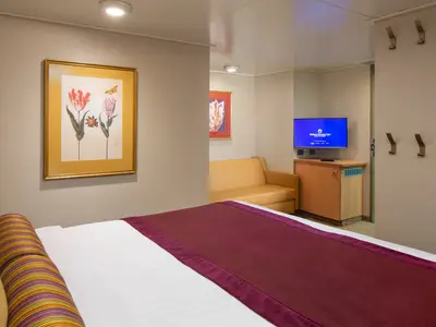 Einblick in eine komfortable Innenkabine an Bord der Zuiderdam mit einem großen Bett, gemütlichem Sofa und Fernseher.