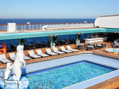 Sonnendeck mit Pool, weißen Liegestühlen und Eisbären-Skulpturen an Bord der Zuiderdam auf hoher See.