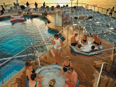 Passagiere genießen die Whirlpools und Liegestühle auf dem Außendeck an Bord der Zuiderdam am späten Nachmittag.