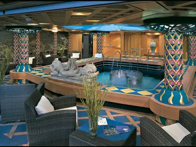 Der Spa-Bereich an Bord der Zuiderdam mit einem Hydrotherapie-Pool, bunten Säulen, Korbsesseln und einer Delfinskulptur.