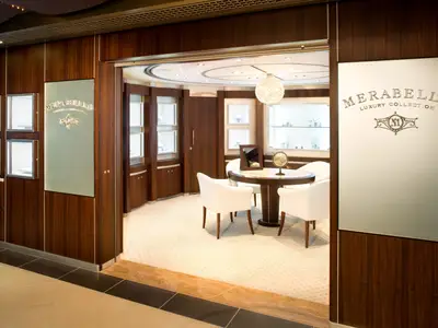 Blick in das edle Juweliergeschäft Merabella Luxury Collection an Bord der Zuiderdam mit edler Holzverkleidung, runder Sitzecke und Vitrinen.