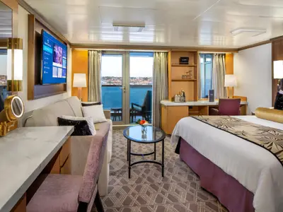 Die elegante Signature Suite an Bord der Zuiderdam bietet ein gemütliches Doppelbett, eine Sitzecke mit Sofa und einen privaten Balkon mit Meerblick.