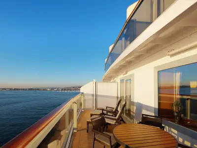 Der weitläufige Balkon einer Neptune Suite an Bord der Zuiderdam mit Liegestühlen und Blick aufs Meer.