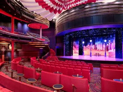 Das zweistöckige Theater an Bord der Zuiderdam mit roten Sesseln und einer beleuchteten Bühne im Pariser Stil.