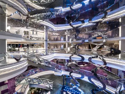 Das Atrium der MSC Bellissima mit einer spiralförmigen Swarovski-Kristalltreppe. Glas und Lichtinstallationen schaffen eine luxuriöse Atmosphäre.