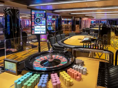 Das beleuchtete Imperial Casino an Bord der MSC Bellissima zeigt einen Roulette-Tisch, gestapelte Chips und moderne Spielautomaten in stilvoller Atmosphäre.