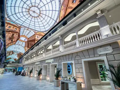 Die Galleria Bellissima an Bord der MSC Bellissima: Eine Ladenpromenade mit Balustrade und einer riesigen LED-Decke, die eine historische Glaskuppel simuliert.