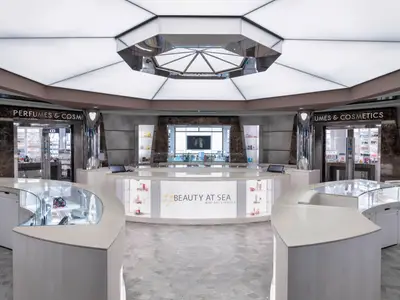Blick in den eleganten Kosmetik- und Parfümerie-Shop "Beauty at Sea" an Bord der MSC Bellissima mit hellen Theken und beleuchteten Vitrinen.