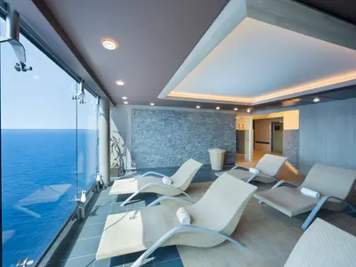 Der moderne Spa-Ruhebereich der MSC Divina mit bequemen Liegen bietet durch raumhohe Glasfronten einen weiten Blick auf das offene Meer.