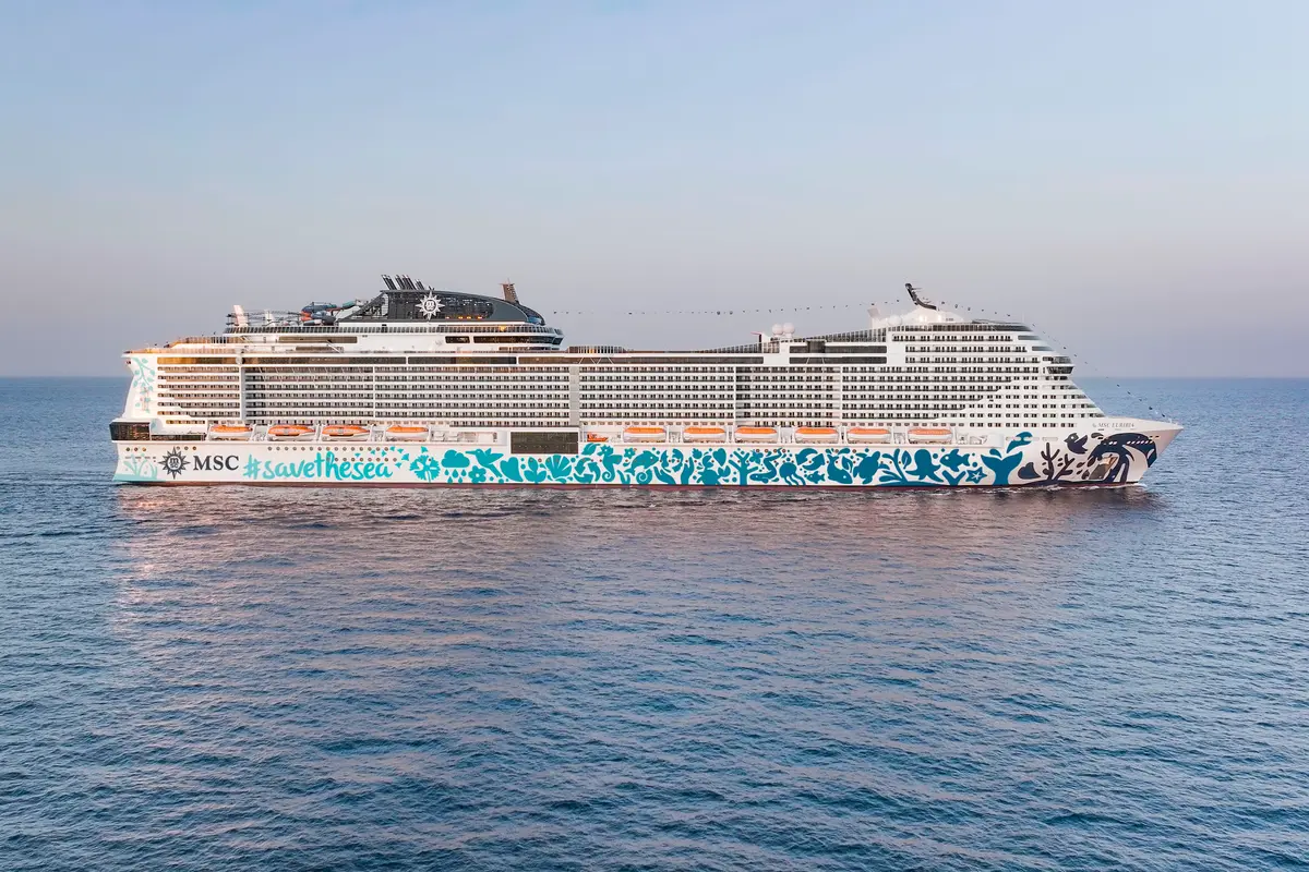 Die MSC Euribia, ein großes Kreuzfahrtschiff mit einer auffälligen türkisen und weißen Rumpfbemalung, fährt auf ruhigem, blauem Meer unter klarem Himmel.