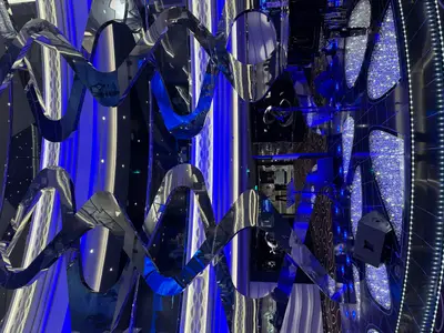 Modern gestaltetes Atrium an Bord der MSC Euribia mit spiegelnden Skulpturen und blauer Lichtinstallation.