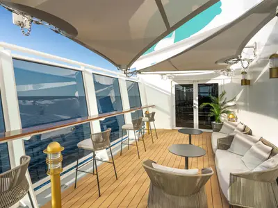 Die überdachte Carousel Terrace an Bord der MSC Euribia bietet bequeme Loungemöbel und Barhocker mit Blick auf das offene Meer. Ein entspannter Ort im Freien.