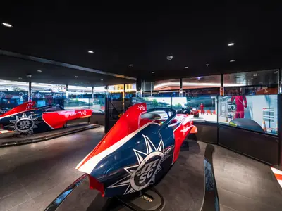 Im Entertainment-Bereich der MSC Euribia stehen zwei Formel-Rennwagen-Simulatoren in Rot, Blau und Weiss. Grosse Bildschirme zeigen digitale Rennszenen und Boxenstopps. Der Raum ist modern und dunkel.