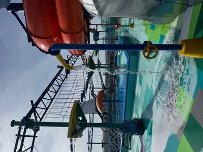 Blick auf den farbenfrohen Wasser-Spielbereich an Bord der MSC Euribia mit Wasserspielen und einem Kletterparcours unter freiem Himmel.
