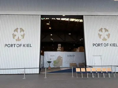 Das geöffnete Tor des Terminals im Port of Kiel mit Info-Bannern vor dem Boarding der MSC Euribia.