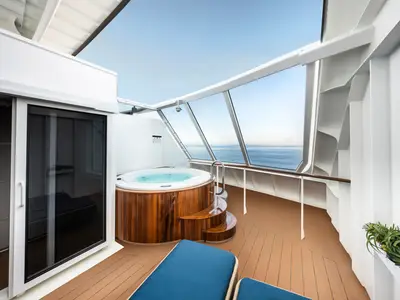 Eine geräumige private Terrasse mit Whirlpool und Meerblick, Teil einer MSC Yacht Club Duplex Suite an Bord der MSC Euribia. Eine Liege steht bereit.