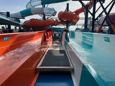 Blick auf zwei parallele Rutschbahnen in Orange und Türkis an Bord der MSC Euribia mit Einstiegsbereich.