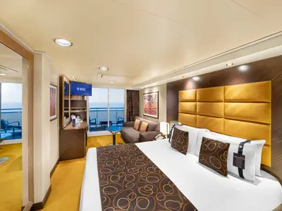 Helle Balkonkabine an Bord der MSC Fantasia mit Doppelbett und Meerblick. Die Kabine ist modern und komfortabel eingerichtet, ideal fuer eine entspannte Reise. Mit Sofa und Balkon.