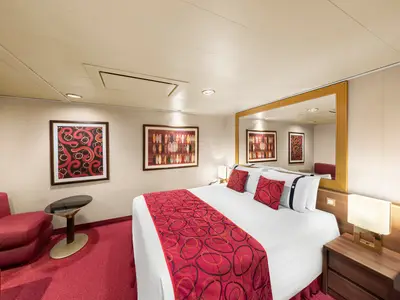 Eine helle und geräumige Innenkabine an Bord der MSC Fantasia mit Doppelbett, rotem Teppich, Kunstwerken an den Wänden und einem großen Spiegel.