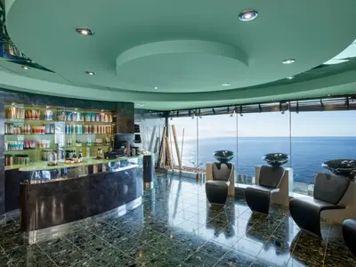 Haarsalon des MSC Aurea Spa an Bord der MSC Fantasia. Moderne Friseurwaschbecken mit Meerblick. Links eine Theke mit vielen Pflegeprodukten.